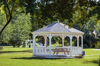 a white gazebo in the middle of a park